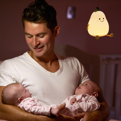 Dans une chambre papa attentionné regarde c'est deux jumeaux grâce veilleuse bébé.