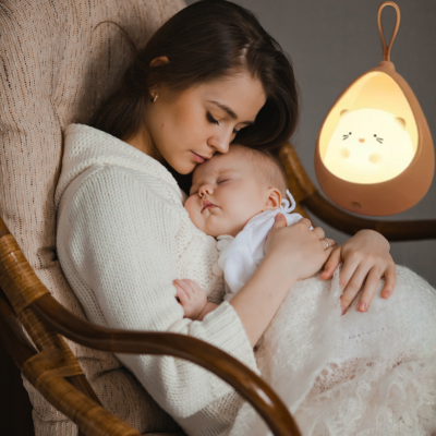 Confortablement installée dans un fauteuil maman berce son enfant pour un sommeil comblé.