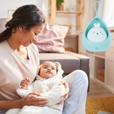 Maman sourit tendrement à son bout de chou dans ses bras confiant avec veilleuses bébé.