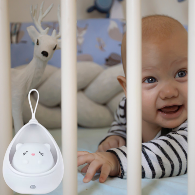 Un bout de chou curieux et joyeux avec 
veilleuse bébé explore son petit monde dans son berceau.