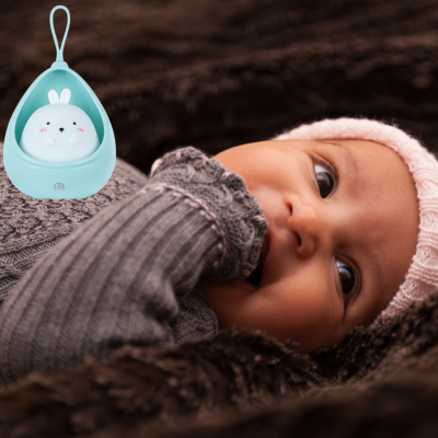 Allongé confortablement une petite fille dans un cocon accompagné avec veilleuse bébé.