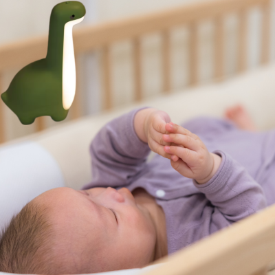 À longer bébé relaxe jouet avec ses doigts près de veilleuse pour bébé. 